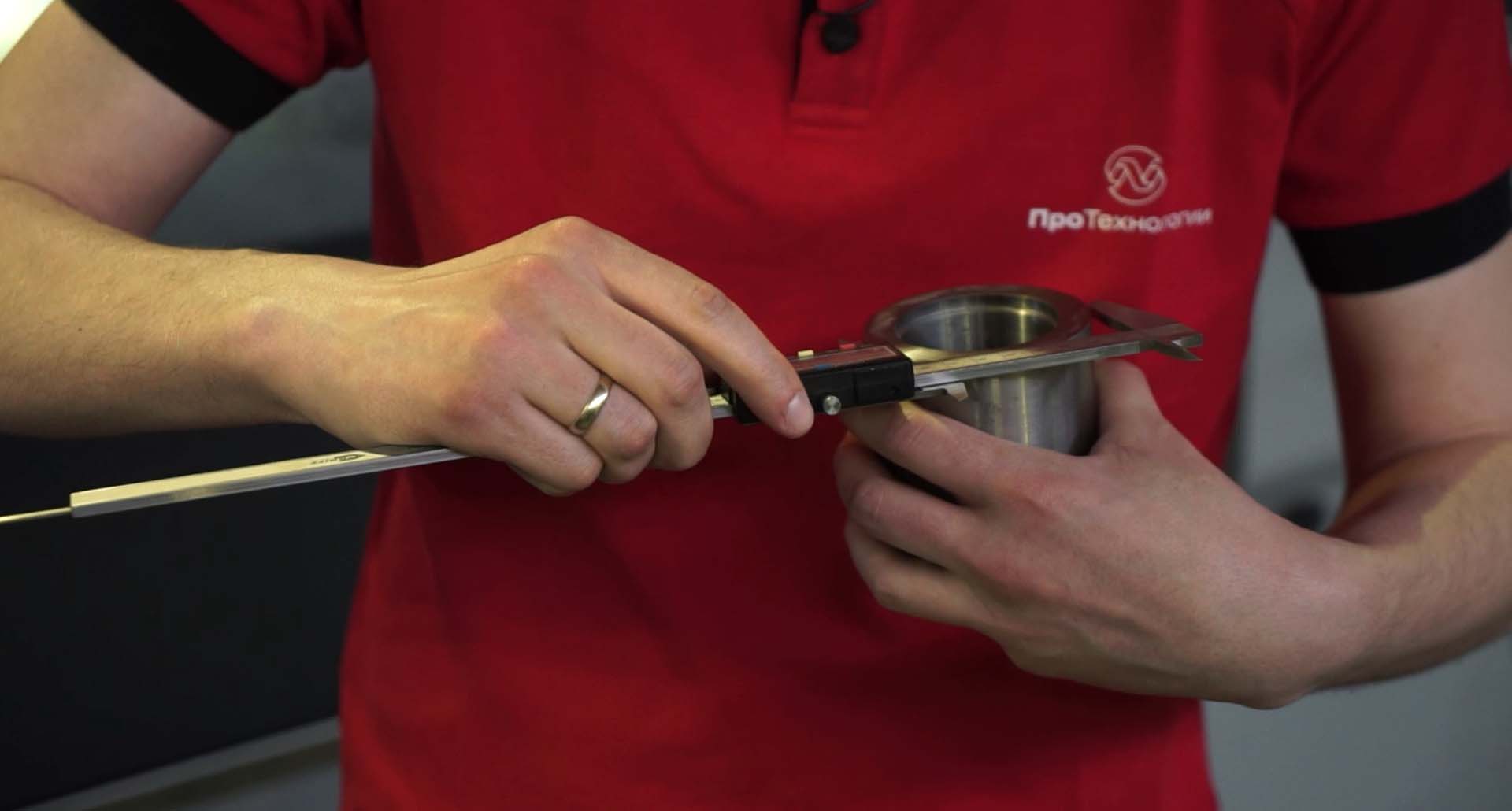 Оператор станка с ЧПУ осуществляет проверку качества готовых деталей